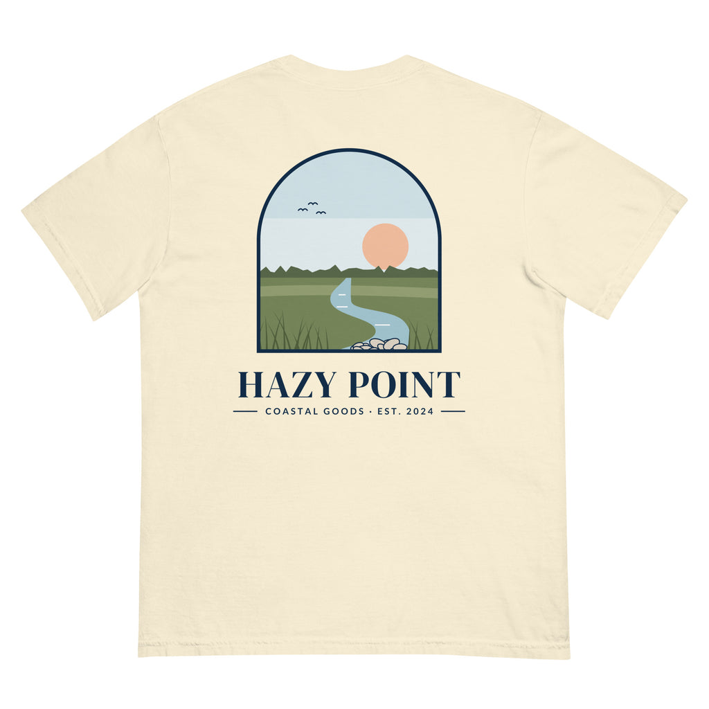 Back of the ivory Hazy Point Spartina Window Tee: an arched window looking onto spartina marsh grass, a winding tidal creek and a low sun, above the HAZY POINT wordmark and EST. 2024