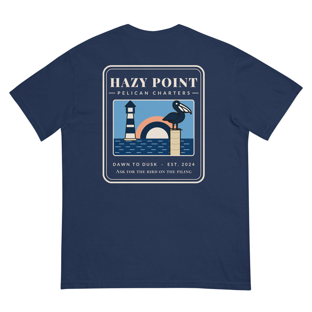 Back of the true navy Hazy Point Pelican Charters Tee: a pelican on a piling beside a striped lighthouse under an arc of sunrise, captioned like a charter office sign